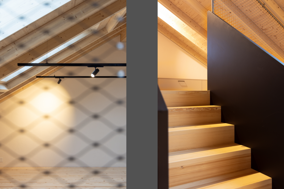 Holztreppe im Neubau einer Wohnscheune mit sichtbarer Holzkonstruktion, Glasgeländer und natürlichem Lichteinfall.