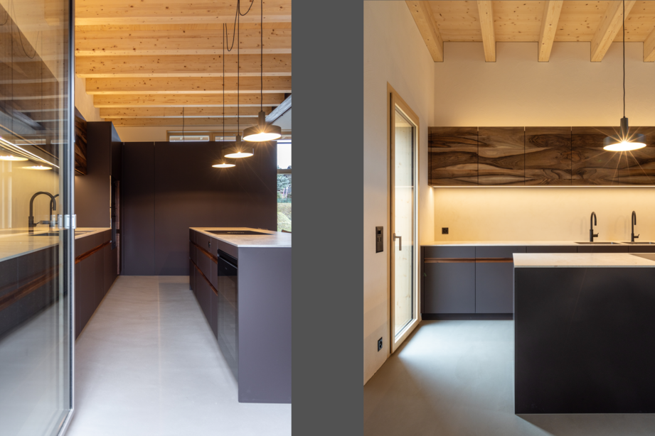 Innenraum eines sanierten Bauernhauses mit sichtbarer Holzbalkendecke, moderner Küche und hochwertigem Holzinnenausbau.