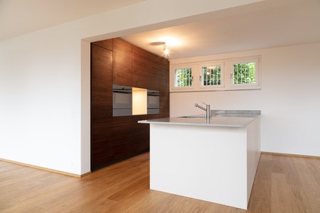 Zeigt moderne Küche mit Nussbaumfurnier in einem Einfamilienhaus in Aarau. Umbau von Einfamilienhaus in Aarau. Anbau in Aarau. 